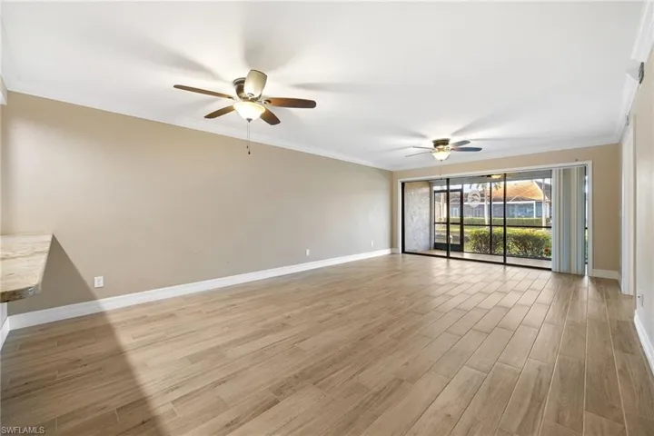 Living room featuring crown molding, light wood finished floors, and ceiling fan