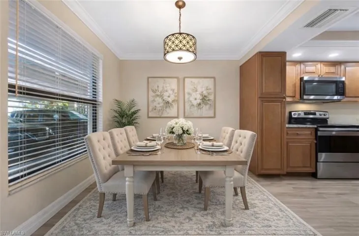 Virtually staged Dining area featuring crown molding and light wood-style flooring