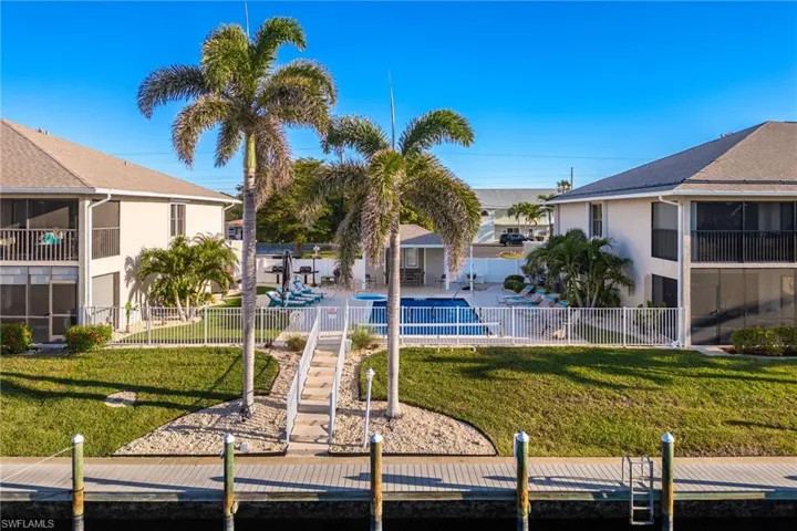 View of property's community with a sunroom, a fenced backyard, and a pool