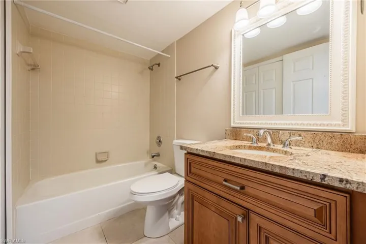 Full bathroom featuring light tile patterned floors, vanity, and shower / tub combination