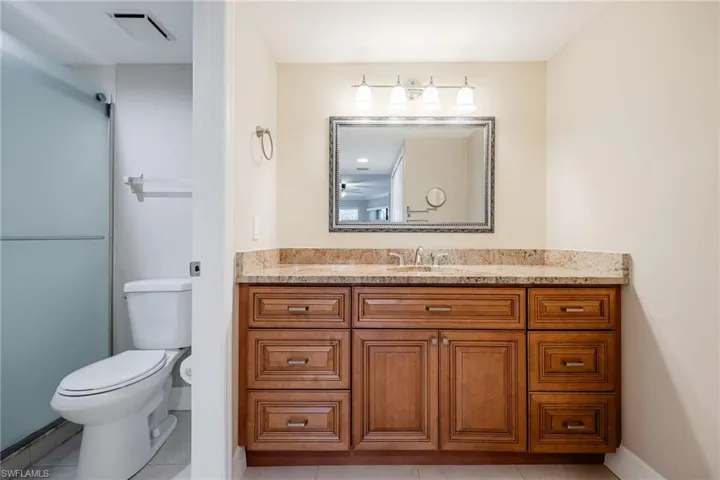 Full bathroom with vanity, light tile patterned floors, and a shower with shower door