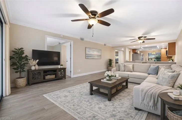 Virtually staged Living room featuring ornamental molding, light wood finished floors, and ceiling fan