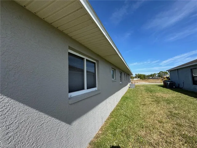 View of home's exterior featuring central AC unit and a lawn