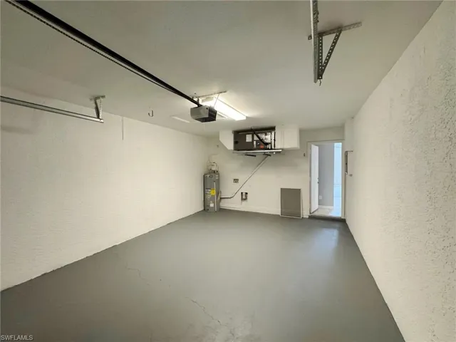 Garage featuring water heater and a garage door opener