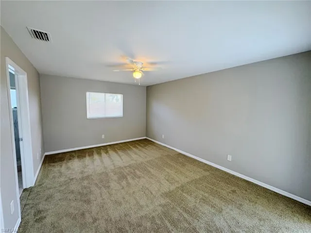 Empty room featuring carpet and ceiling fan
