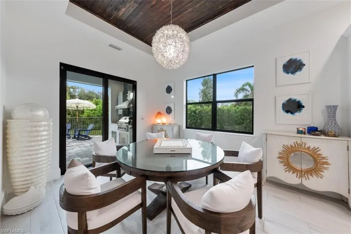 Dining area featuring an inviting chandelier and a tray ceiling with a wood in lay.