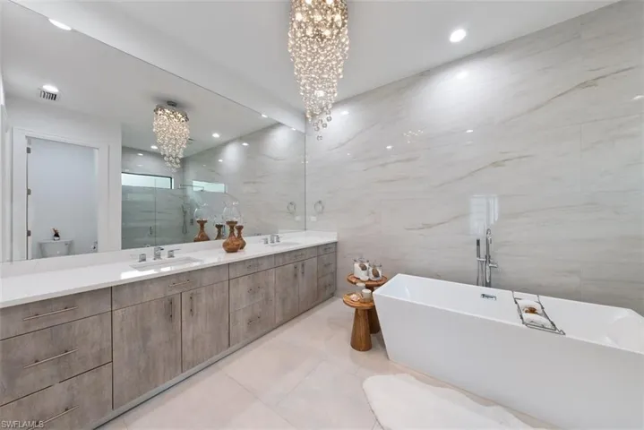 Owner's bathroom with dual sinks, standalone bathtub and a water closet.