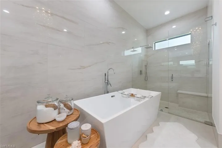 Bathroom featuring tile walls, tile patterned flooring, and independent shower and bath