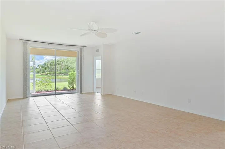 Spare room featuring light tile patterned flooring, plenty of natural light, and a ceiling fan