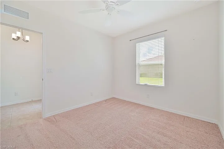 bedroom with light carpet, a ceiling fan, and a chandelier