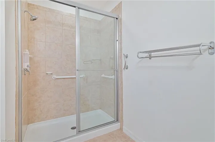 Full bath with a shower stall and tile patterned flooring