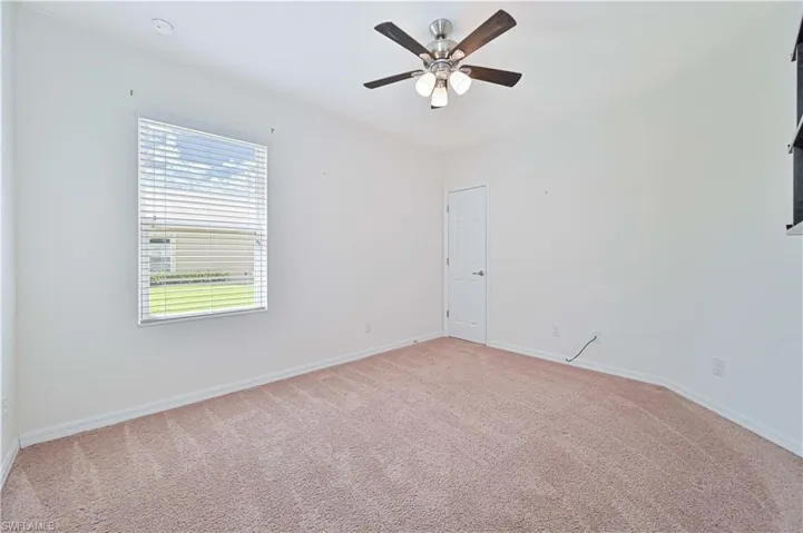 Spare room with light colored carpet and a ceiling fan
