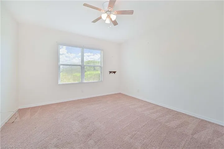 Unfurnished room featuring light colored carpet and ceiling fan