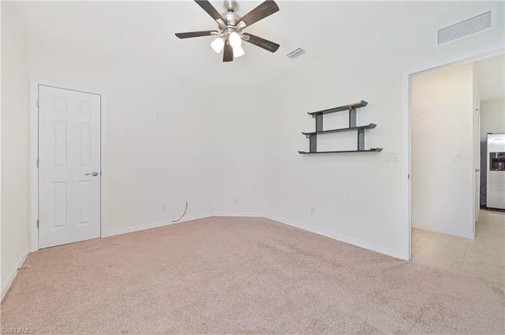 Spare room featuring light carpet and ceiling fan