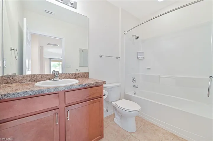 Full bathroom featuring tile patterned flooring, shower / bath combination, and vanity