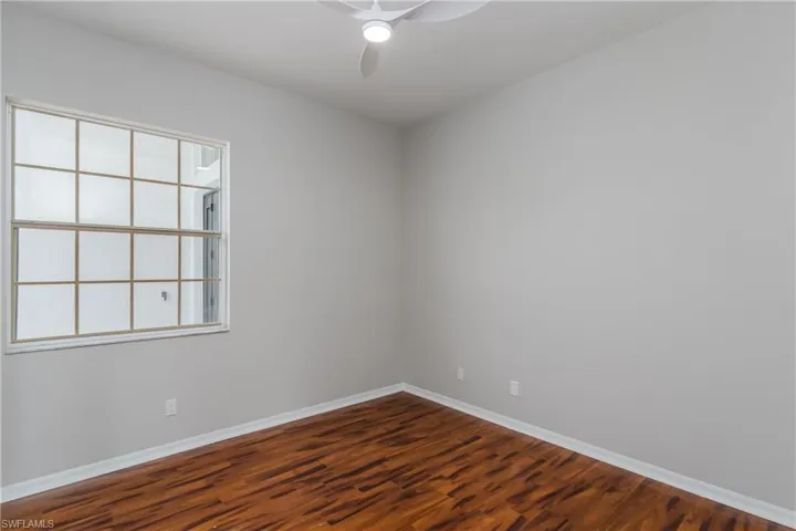 Empty room with wood finished floors and ceiling fan
