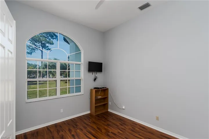 Empty room featuring dark wood-type flooring and ceiling fan