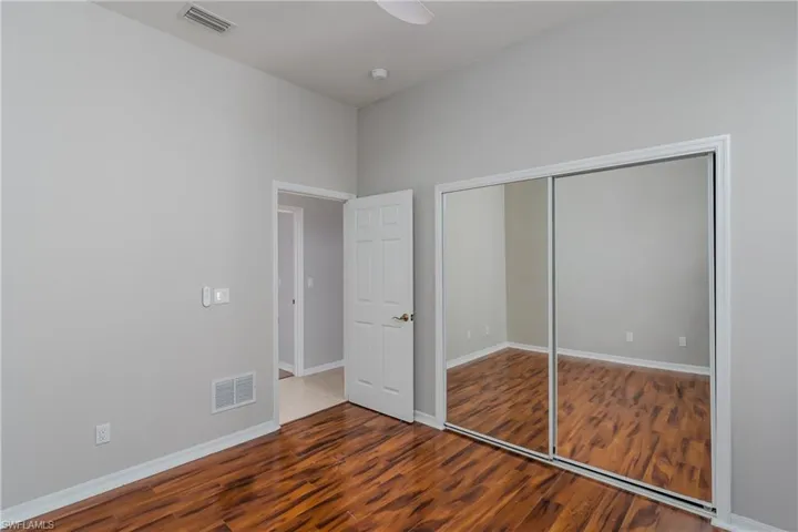 Unfurnished bedroom featuring wood finished floors, ceiling fan, and a closet