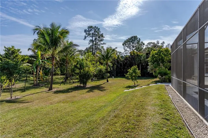 View of green lawn featuring a lanai and a sunroom