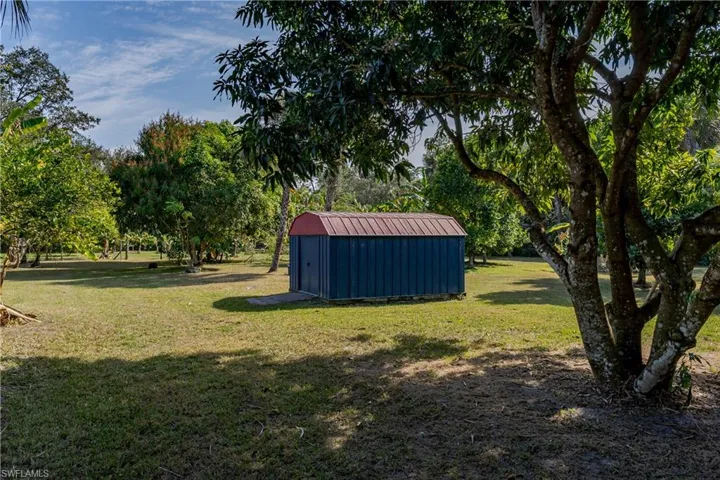 View of grassy yard with a storage shed