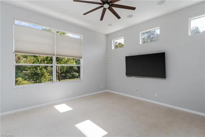 Empty room with ceiling fan and light tile patterned floors