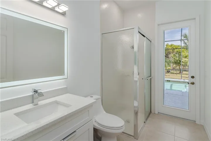 Full bathroom with vanity, a stall shower, and light tile patterned flooring