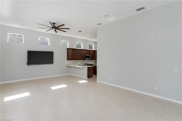Unfurnished living room featuring a ceiling fan, recessed lighting, and light tile patterned floors