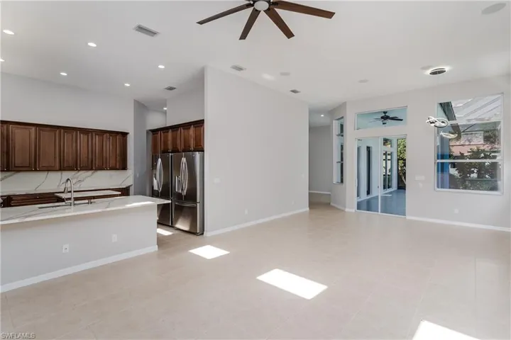 Kitchen with pendant lighting, open floor plan, dark brown cabinetry, recessed lighting, and a ceiling fan