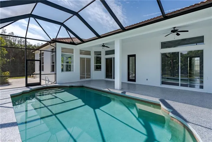 Outdoor pool with a sunroom, a lanai, and a patio area