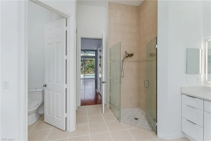 Full bath featuring a shower stall, vanity, and light tile patterned floors