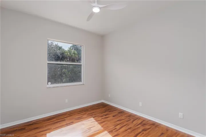 Empty room with wood finished floors and ceiling fan