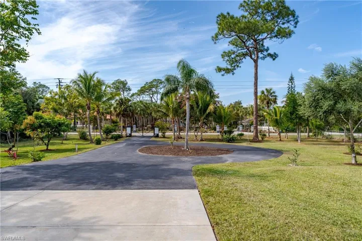 View of property's community featuring a yard and curved driveway