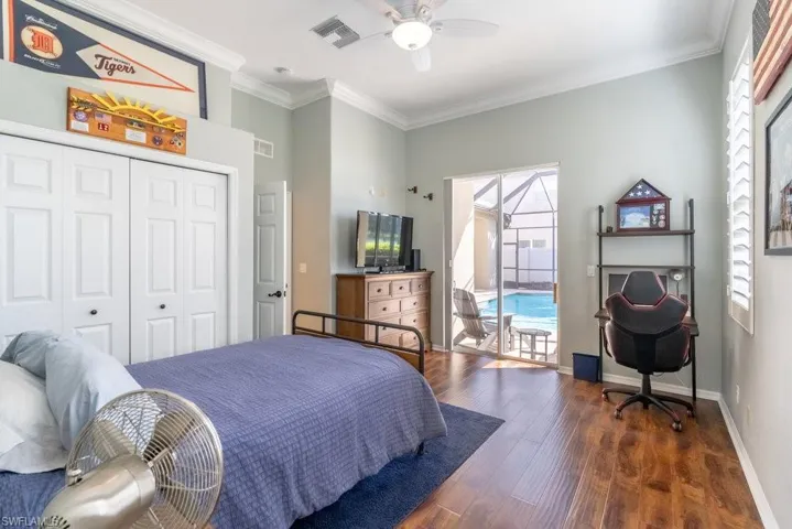Bedroom with a closet, dark hardwood / wood-style floors, multiple windows, and ceiling fan