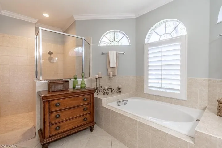 Bathroom featuring separate shower and tub, tile patterned floors, and ornamental molding