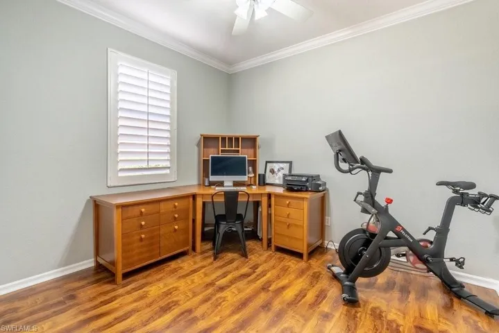 Office featuring ceiling fan, ornamental molding, and hardwood / wood-style flooring