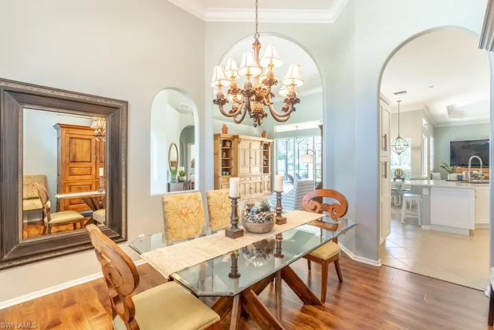 Dining room with sink, ornamental molding, a high ceiling, and hardwood / wood-style flooring