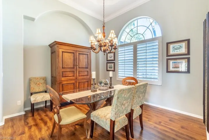 Dining area featuring ornamental molding, a chandelier, and dark hardwood / wood-style flooring