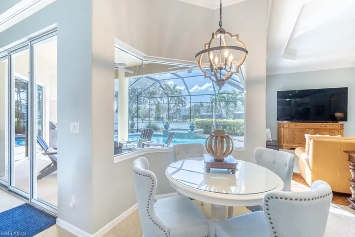Dining room with ornamental molding, an inviting chandelier, and plenty of natural light