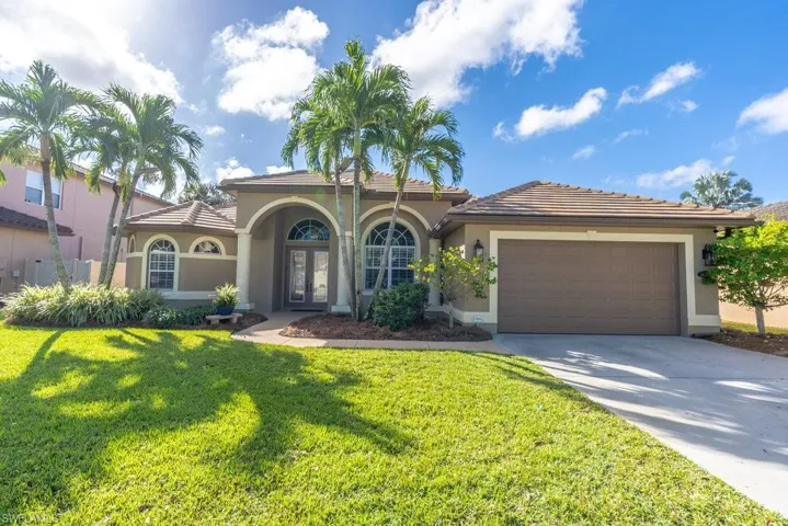 Mediterranean / spanish home with a garage and a front lawn