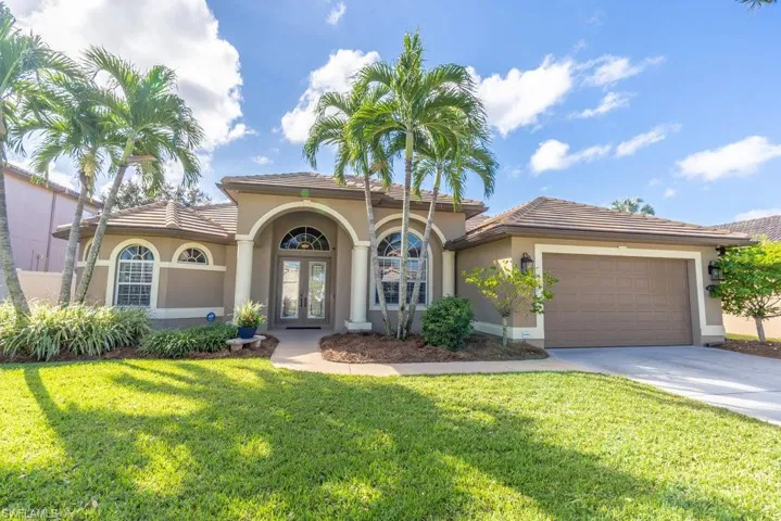 Mediterranean / spanish house with french doors, a garage, and a front lawn