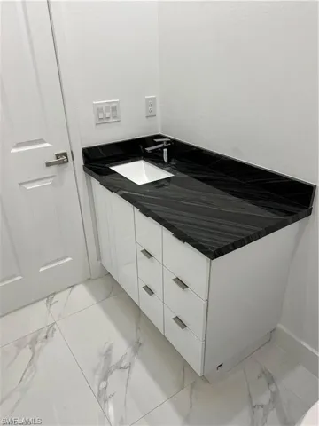 Bathroom with tile patterned floors and vanity