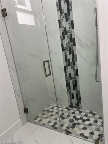Bathroom featuring an enclosed shower and tile patterned flooring
