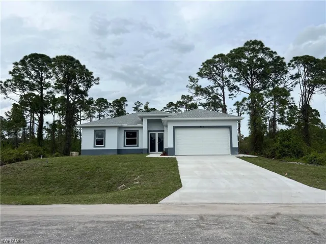 View of front facade featuring a garage and a front yard