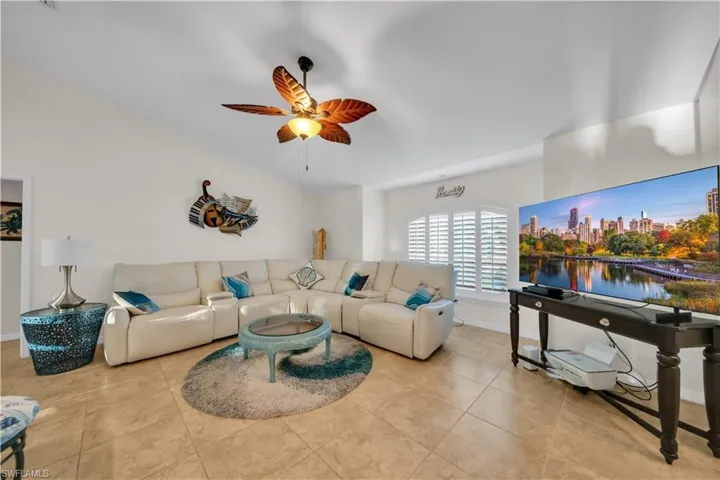 Living area featuring ceiling fan and light tile patterned flooring