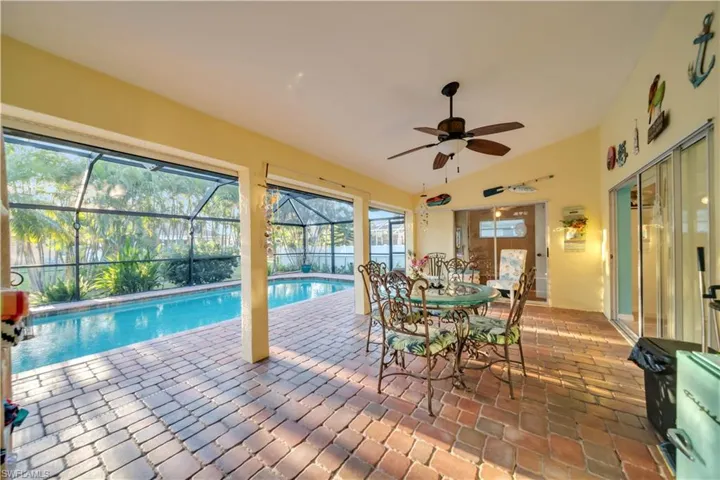 Outdoor pool with a lanai, a sunroom, a patio, and outdoor dining space