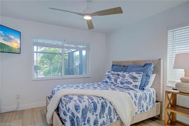 Bedroom featuring a ceiling fan, baseboards, and wood finished floors