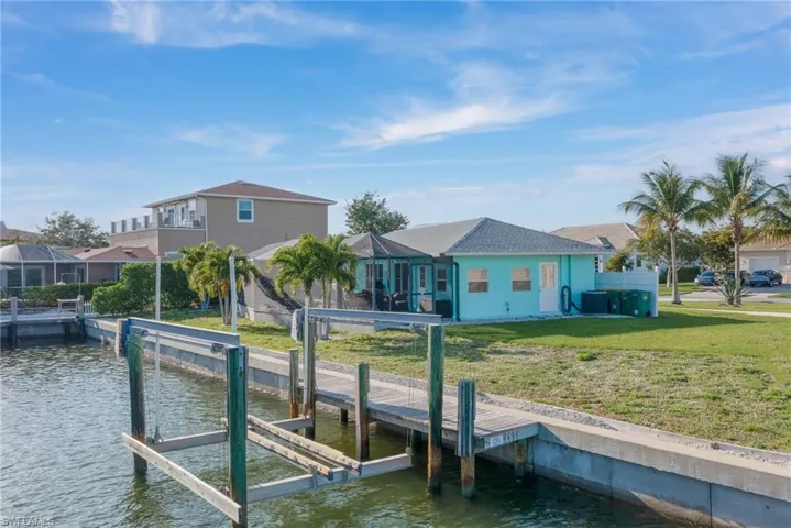 Dock area with central AC unit, a lawn, a water view, and a residential view