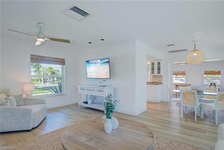 Living area featuring light wood-style flooring, visible vents, and a ceiling fan