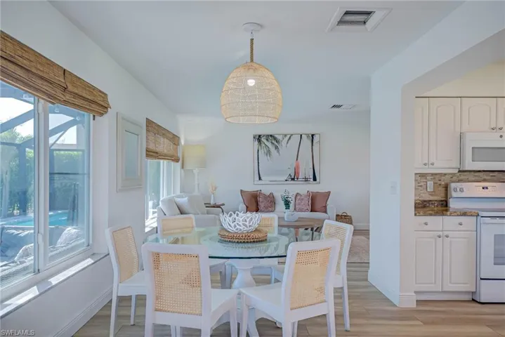 Dining space with baseboards, visible vents, and light wood-type flooring