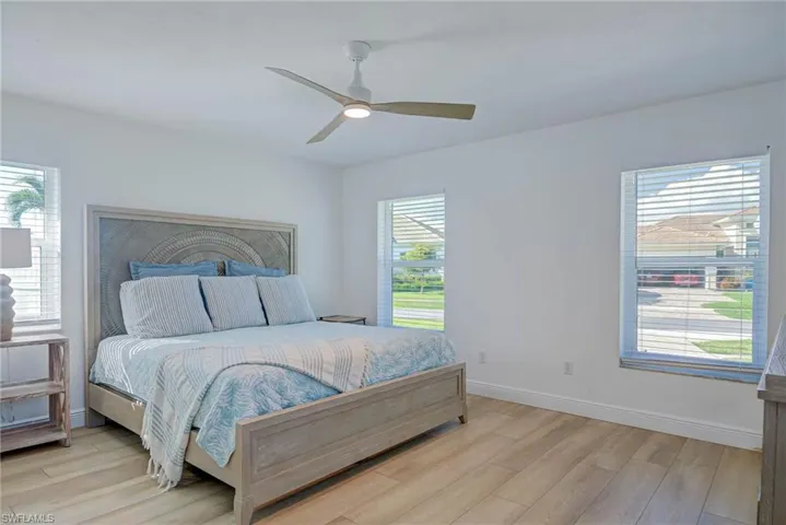 Bedroom with baseboards, wood finished floors, and ceiling fan